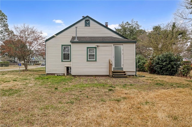 rear view of house with a yard, fence, and entry steps