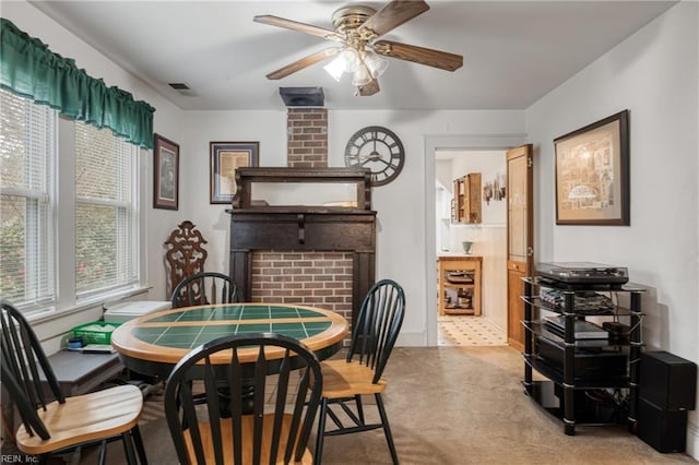 dining space with light carpet, visible vents, and ceiling fan