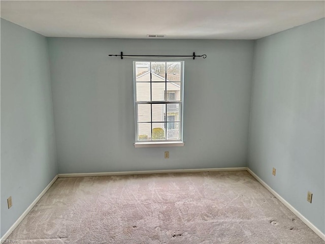 spare room featuring visible vents, baseboards, and carpet