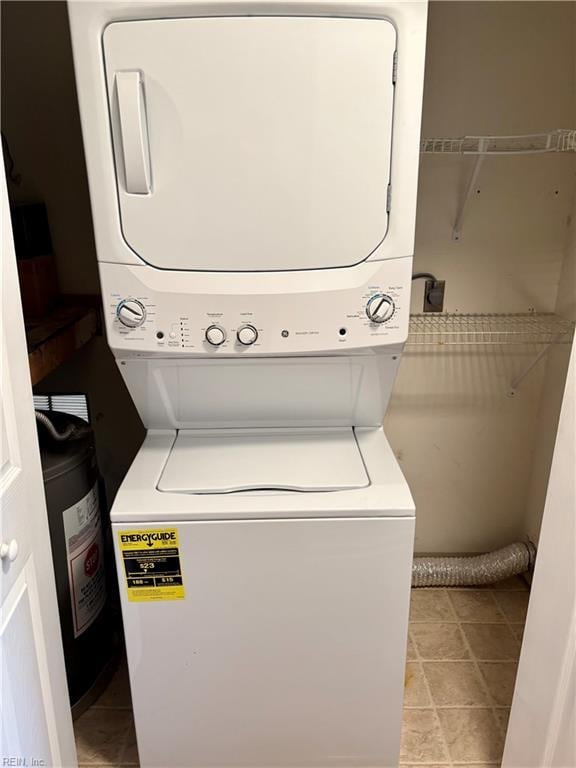 washroom with stacked washer and clothes dryer, light tile patterned flooring, and laundry area