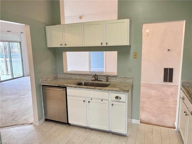 kitchen featuring visible vents, light carpet, a sink, light stone counters, and stainless steel dishwasher