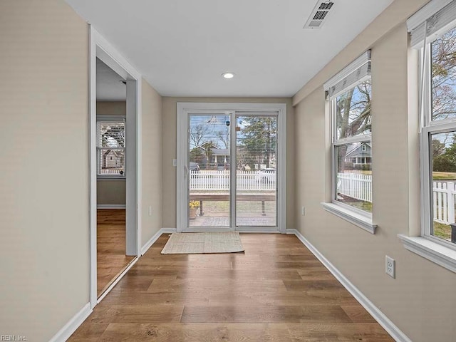 doorway featuring visible vents, baseboards, and wood finished floors