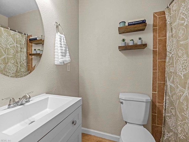 full bathroom with vanity, wood finished floors, baseboards, curtained shower, and toilet