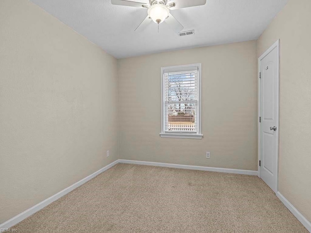 unfurnished room with baseboards, a ceiling fan, visible vents, and light carpet