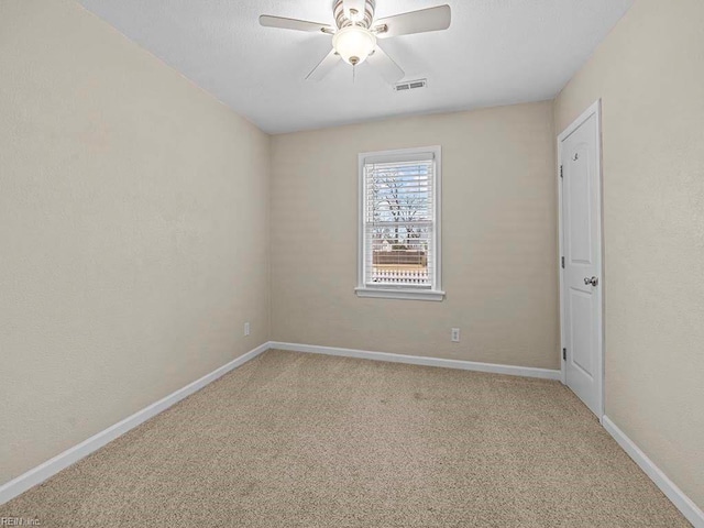 empty room with a ceiling fan, visible vents, carpet floors, baseboards, and a textured wall