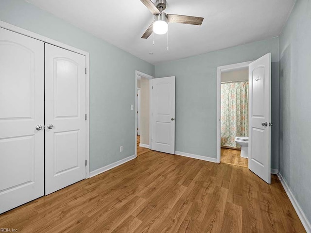 unfurnished bedroom featuring a closet, ensuite bathroom, light wood-type flooring, and baseboards