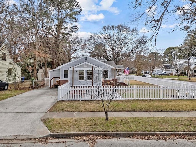 bungalow-style home with a fenced front yard and driveway