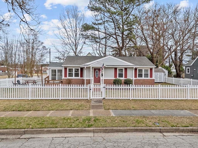 ranch-style house featuring a fenced front yard and brick siding