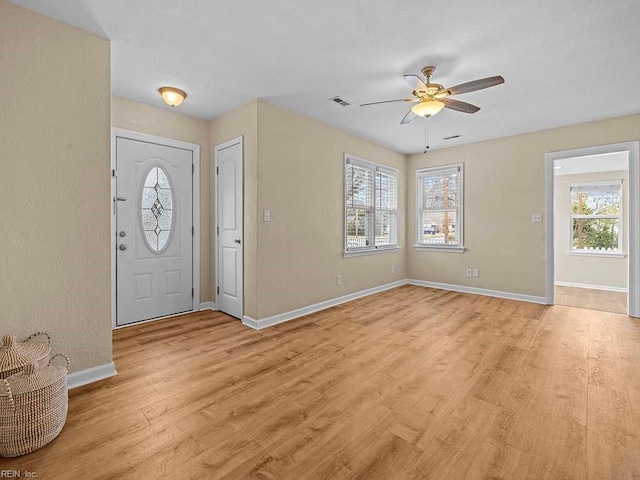 foyer featuring light wood finished floors, plenty of natural light, baseboards, and ceiling fan