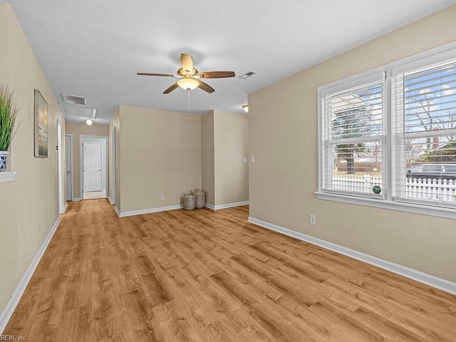 interior space with light wood-style floors, a ceiling fan, visible vents, and baseboards