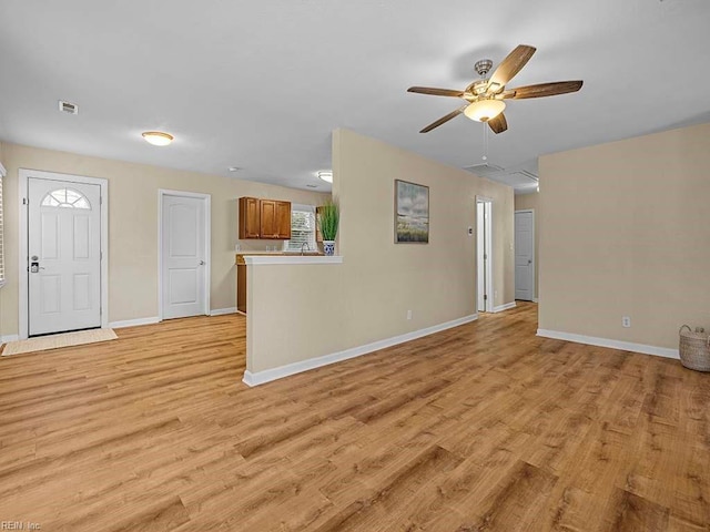 unfurnished living room with visible vents, baseboards, ceiling fan, and light wood-style flooring