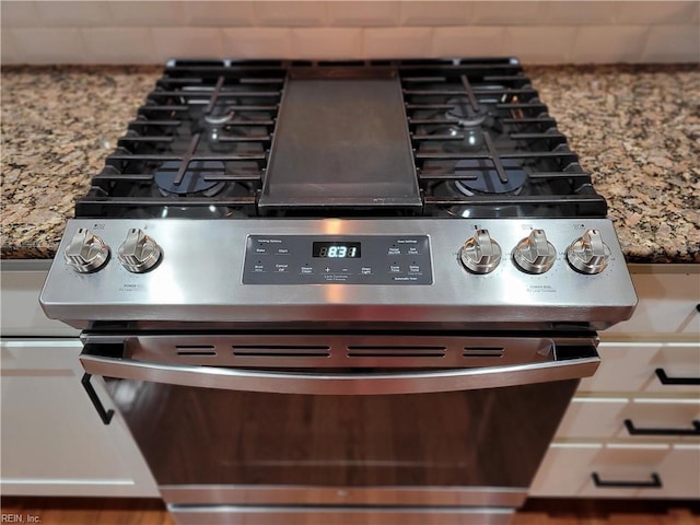 room details featuring gas range and light stone countertops