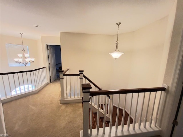 staircase featuring an inviting chandelier and carpet floors