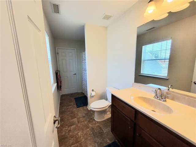 bathroom with visible vents, toilet, and vanity