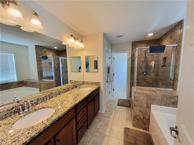 full bathroom with visible vents, a shower stall, a garden tub, and a sink