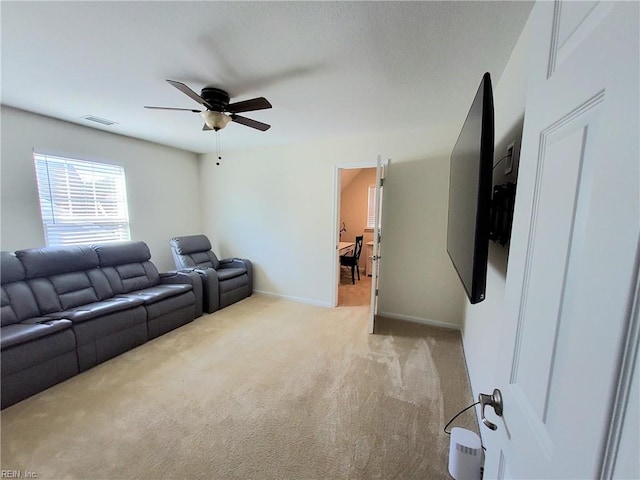 living room with visible vents, light carpet, baseboards, and a ceiling fan