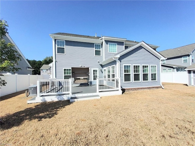 rear view of house featuring cooling unit and a fenced backyard