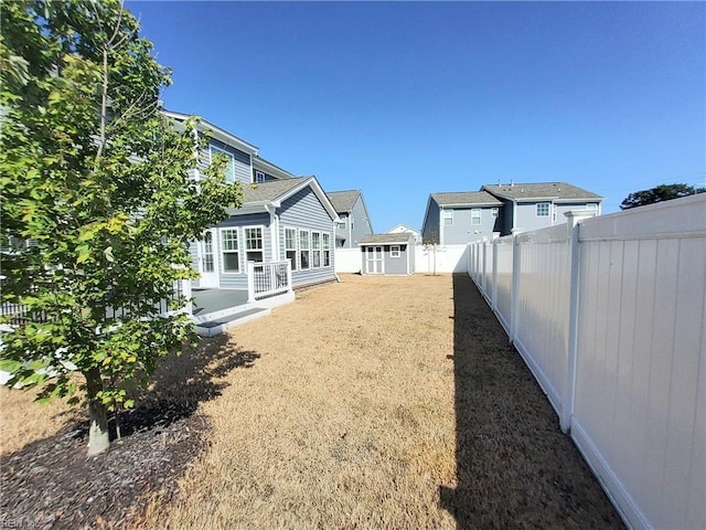 view of yard featuring an outdoor structure and a fenced backyard