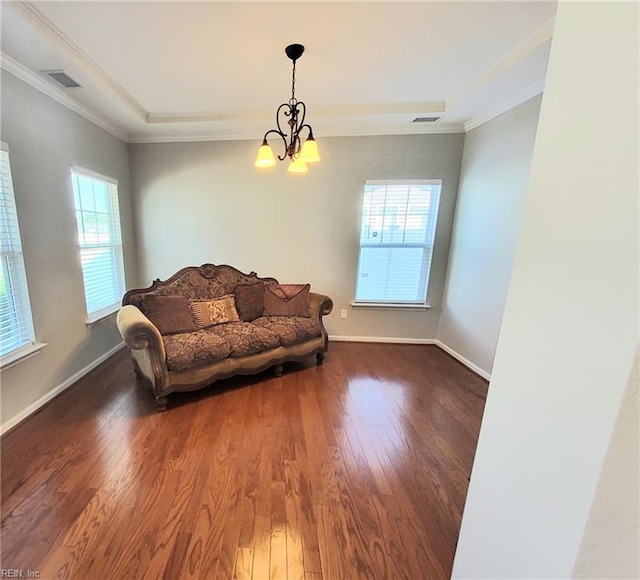 living room with visible vents, baseboards, wood finished floors, and crown molding