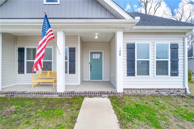 property entrance with covered porch and roof with shingles