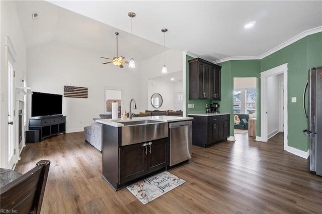 kitchen with dark wood-style floors, a sink, stainless steel appliances, light countertops, and open floor plan