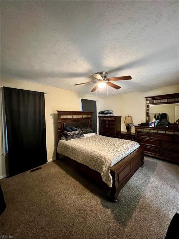 bedroom with a ceiling fan, carpet, visible vents, and a textured ceiling