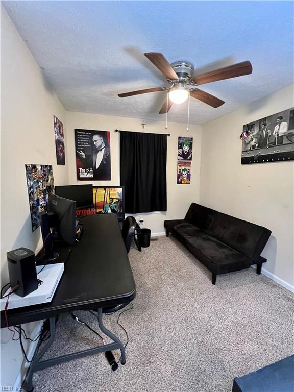 office space with baseboards, carpet flooring, a textured ceiling, and a ceiling fan