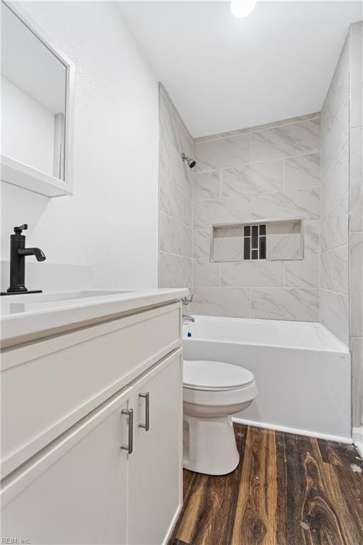 bathroom featuring tub / shower combination, toilet, wood finished floors, and vanity