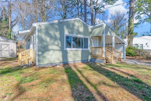 view of front of house with a storage shed, a front yard, and an outdoor structure