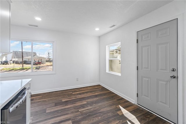 entryway featuring visible vents, baseboards, dark wood-style flooring, and a textured ceiling