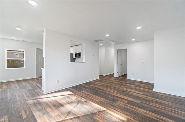 spare room with recessed lighting, dark wood-style flooring, and baseboards