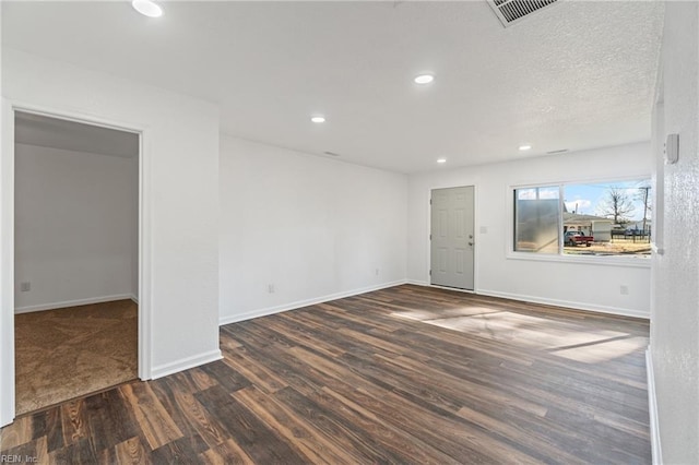 spare room featuring wood finished floors, visible vents, baseboards, recessed lighting, and a textured ceiling