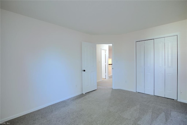 unfurnished bedroom featuring a closet, baseboards, and carpet