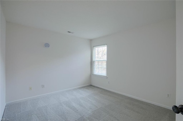 carpeted empty room with visible vents and baseboards