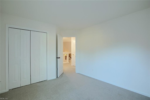 unfurnished bedroom featuring a closet, baseboards, and carpet