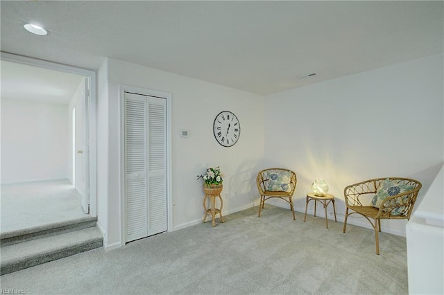 sitting room with carpet flooring, baseboards, and visible vents