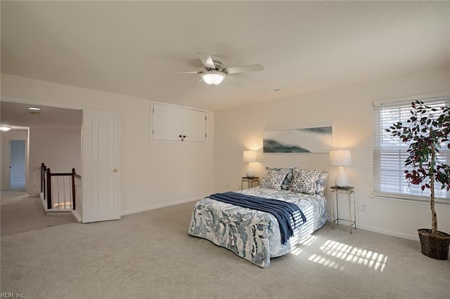 bedroom with light carpet, ceiling fan, and baseboards