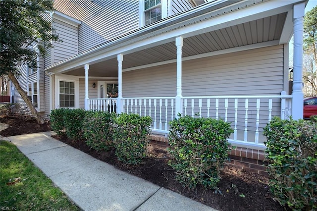 view of exterior entry featuring covered porch