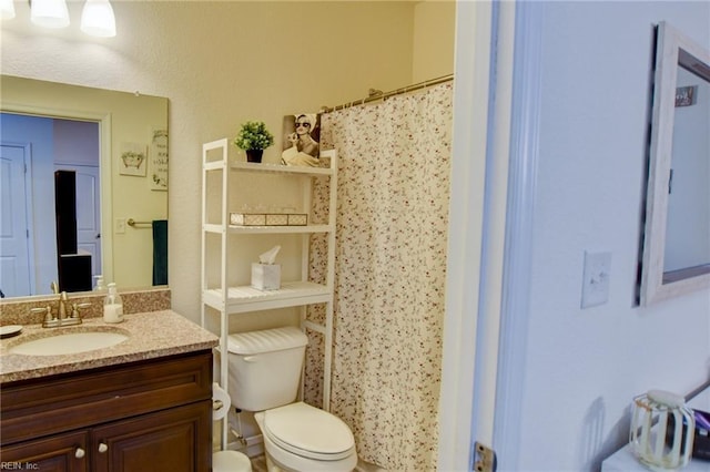 bathroom featuring vanity, curtained shower, and toilet