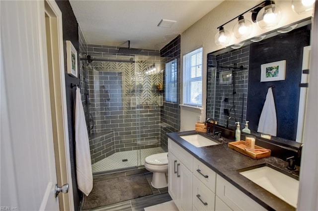 full bath featuring a sink, toilet, double vanity, and a shower stall