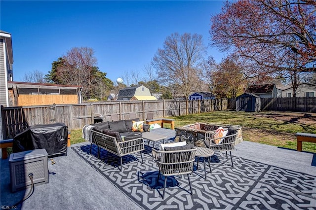 view of patio / terrace with an outdoor living space with a fire pit, an outdoor structure, a fenced backyard, and a shed