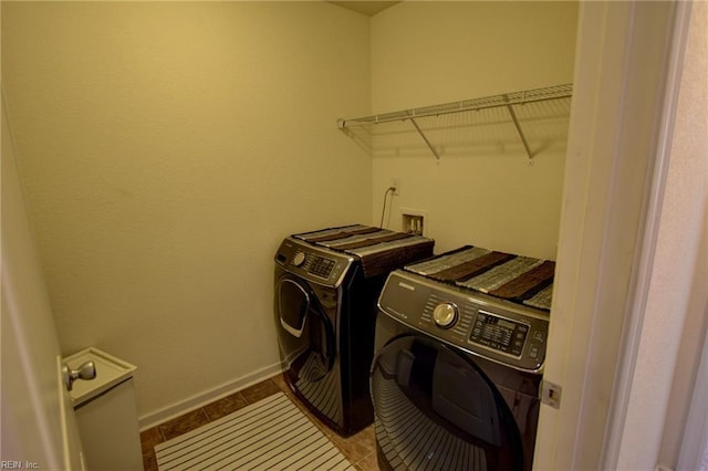 clothes washing area featuring light tile patterned floors, laundry area, baseboards, and separate washer and dryer