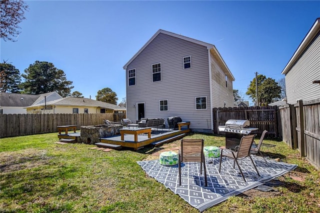 rear view of house with an outdoor living space, a deck, a lawn, and a fenced backyard