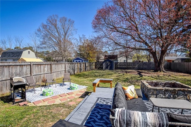 view of yard featuring a patio, a fire pit, an outbuilding, and a fenced backyard