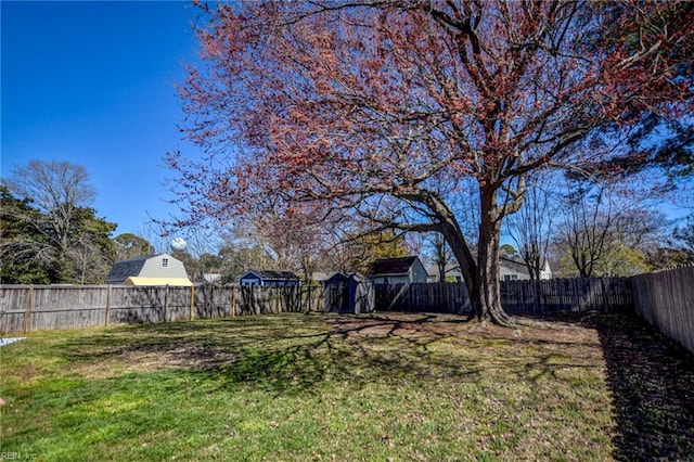 view of yard with an outbuilding, a shed, and a fenced backyard