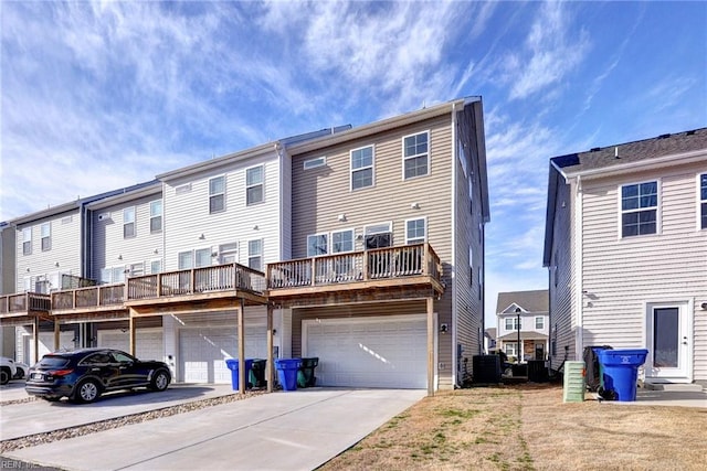 back of property with driveway, an attached garage, and central AC