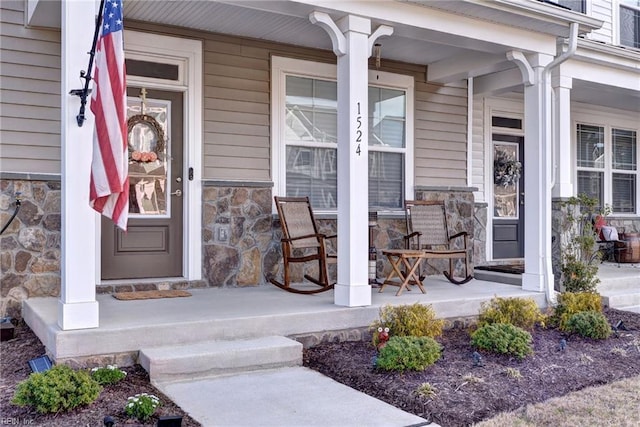 entrance to property featuring stone siding and a porch