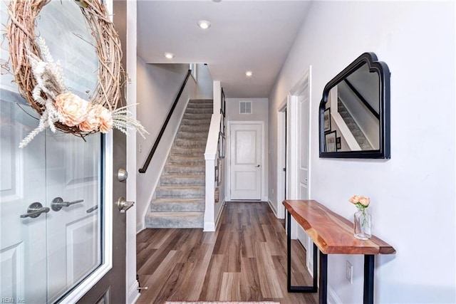 foyer entrance featuring visible vents, wood finished floors, recessed lighting, stairway, and baseboards