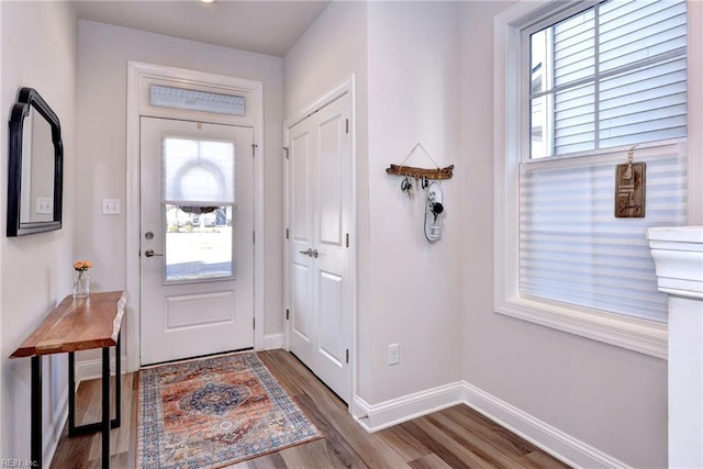 entryway with baseboards and wood finished floors