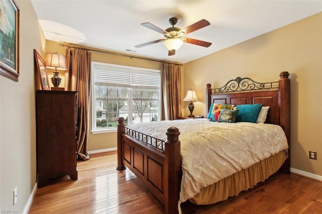 bedroom with visible vents, baseboards, light wood-style floors, and ceiling fan